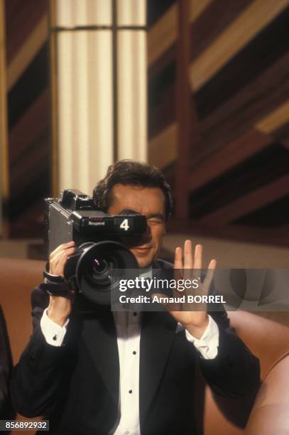 Michel Denisot tenant une caméra sur le plateau de l'émission de télévision 'Ciné Stars' le 8 septembre 1987 à Paris, France.