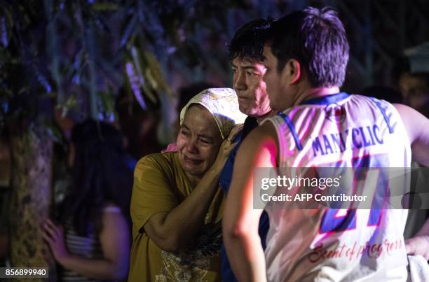 Relatives of Aldrin Castillo, an alleged drug user killed by unidentified assailants, grieve as they arrive at the crime scene in Manila on October...
