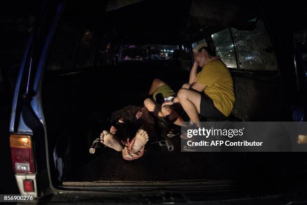 Relatives of Aldrin Castillo, an alleged drug user killed by unidentified assailants, grieve inside the funeral ambulance in Manila on October 3,...
