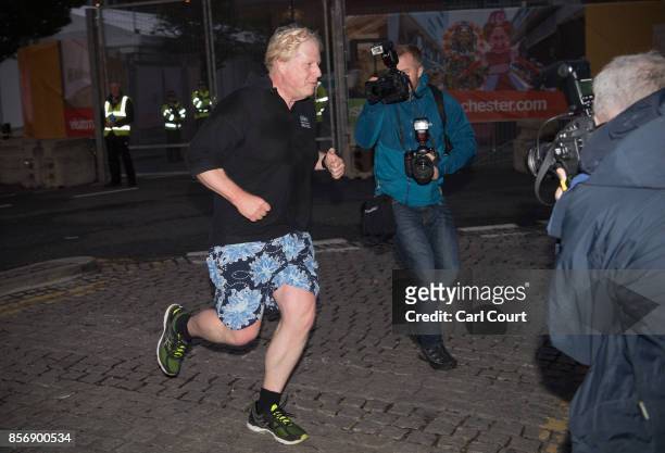 Foreign Secretary Boris Johnson is photographed by news photographers as he returns from his morning jog on day three of the annual Conservative...