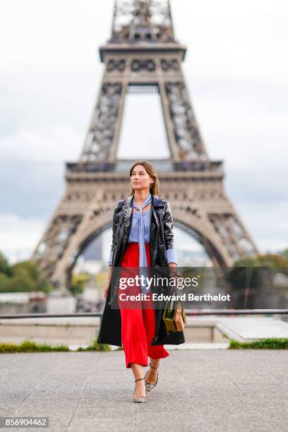 Angelica Ardasheva wears red pants, a blue top, a black coat, outside Hermes, during Paris Fashion Week Womenswear Spring/Summer 2018, on October 2,...