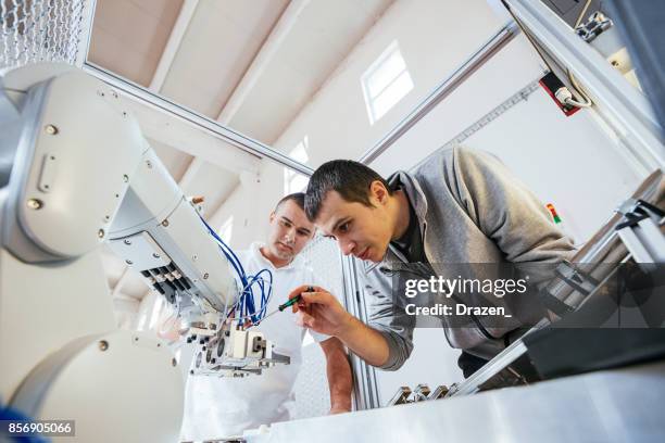 precise mechanics on robotic arm in industry - engineers brainstorming stock pictures, royalty-free photos & images