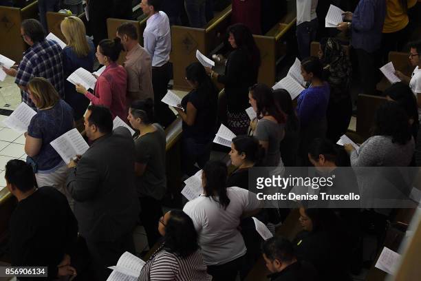 The congregation sing hymns during a vigil at Guardian Angel Cathedral for the victims of the Route 91 Harvest country music festival shootings on...