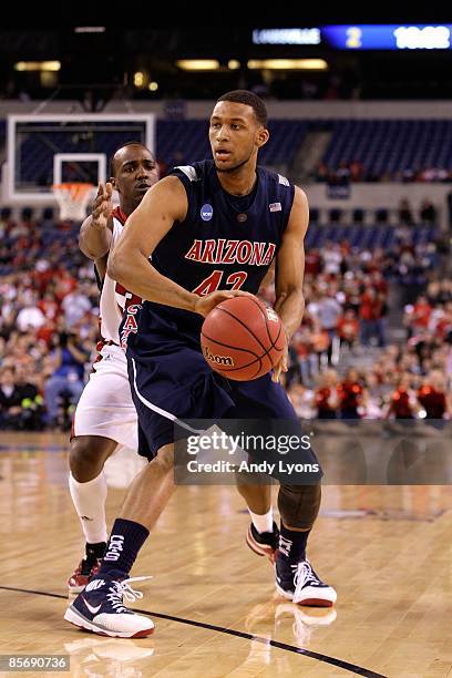 Jamelle Horne of the Arizona Wildcats looks to pass the ball against Andre McGee of the Louisville Cardinals during the third round of the NCAA...