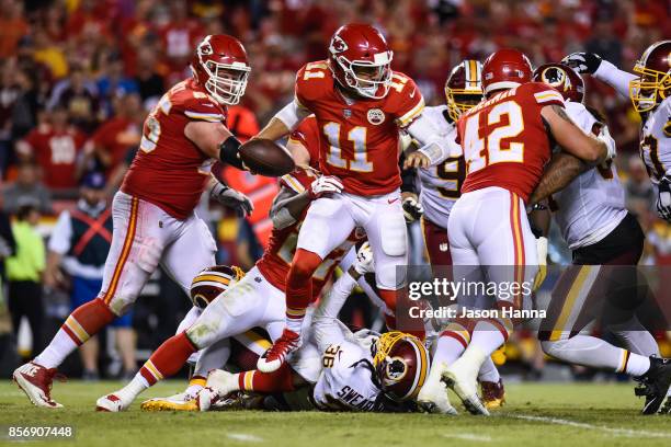 Quarterback Alex Smith of the Kansas City Chiefs tries to run through the sack attempt of free safety D.J. Swearinger of the Washington Redskins...