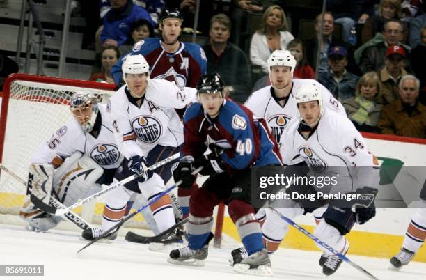 Goaltender Dwayne Roloson of the Edmonton Oilers defends the goal along with Steve Staios, Kyle Brodziak and Fernando Pisani against Marek Svatos and...