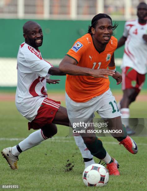 Ivorian National football team "Elephants" striker Didier Drogba duels for the ball with Malawi team captain Peter Mponda on March 29, 2009 at Felix...