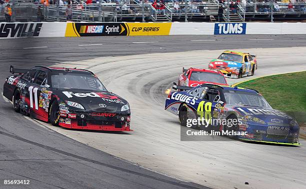 Jimmie Johnson, driver of the Lowe's Chevrolet, passes Denny Hamlin, driver of the FedEx Express Toyota, at turn four during the NASCAR Sprint Cup...