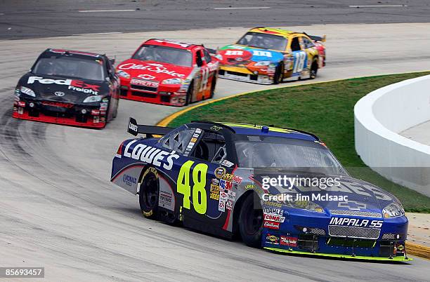 Jimmie Johnson, driver of the Lowe's Chevrolet, leads Denny Hamlin, driver of the FedEx Express Toyota, Tony Stewart, driver of the Office Depot...