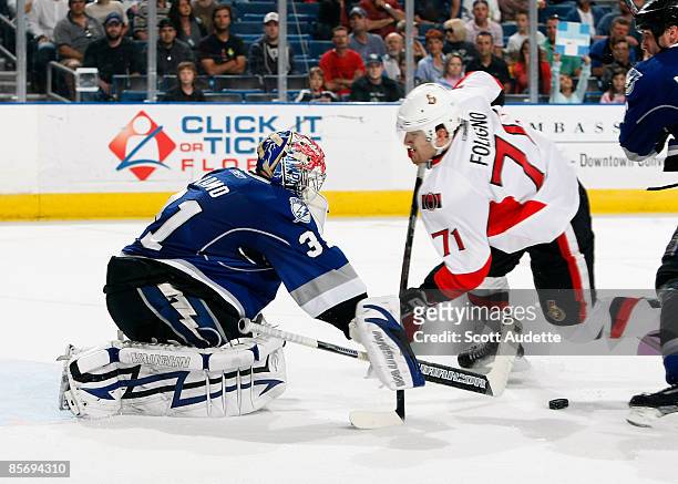 Goaltender Karri Ramo of the Tampa Bay Lightning deflects the puck away being Nick Foligno of the Ottawa Senators collides with him during the second...