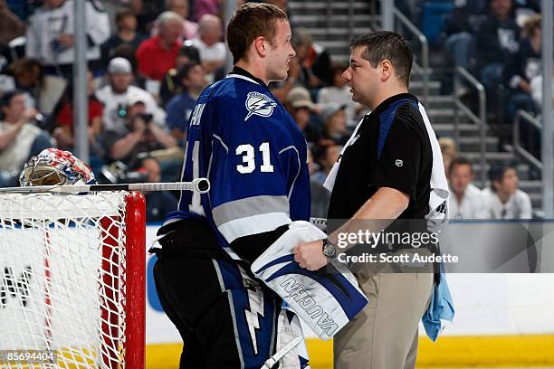 Goaltender Karri Ramo of the Tampa Bay Lightning is checked out by team athletic trainer Tom Mulligan after collision with Nick Foligno of the Ottawa...