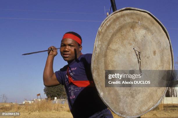 Un jeune homme de nationalite zoulou du mouvement Inkhata avec sa lance et son bouclier dans le township de Kagiso le 23 aout 1990 en Afrique du Sud.