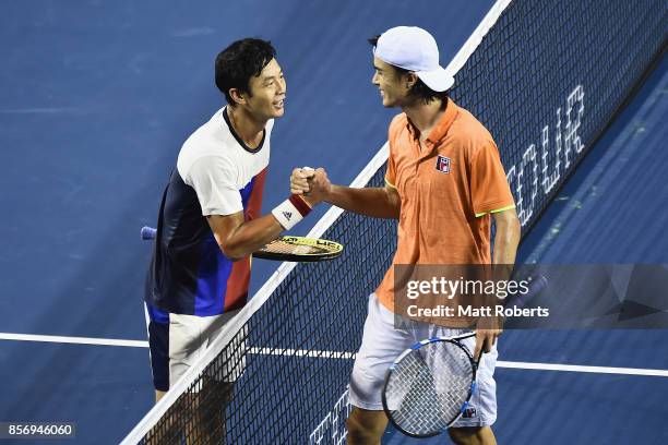 Yen-Hsun Lu of Chinese Taipei and Taro Daniel of Japan shake hands after their match during day two of the Rakuten Open at Ariake Coliseum on October...