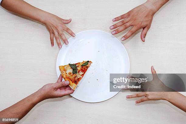 men reaching last pizza from plate - reiken stockfoto's en -beelden