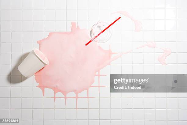 spilt strawberry shake on tiled floor - knoeien stockfoto's en -beelden