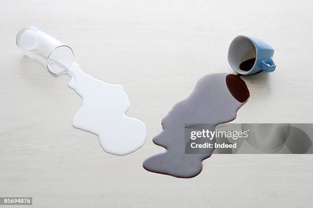 spilit milk and coffee on table - kaffeefleck stock-fotos und bilder