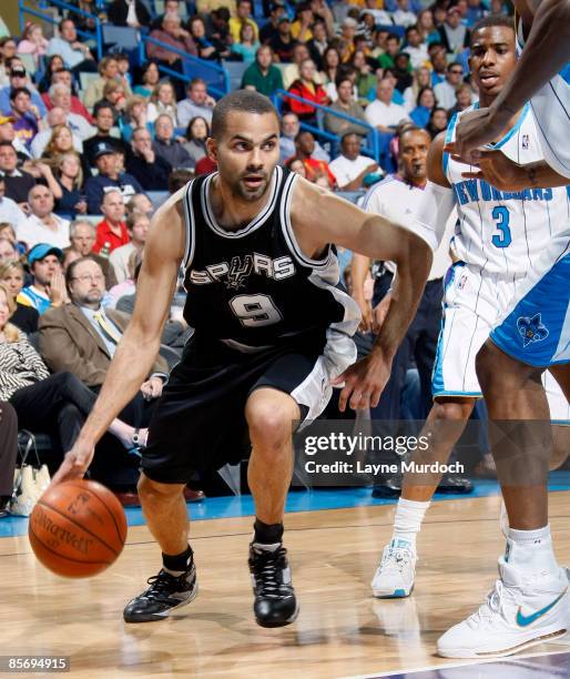 Tony Parker of the San Antonio Spurs drives around Chris Paul and David West of the New Orleans Hornets on March 29, 2009 at the New Orleans Arena in...