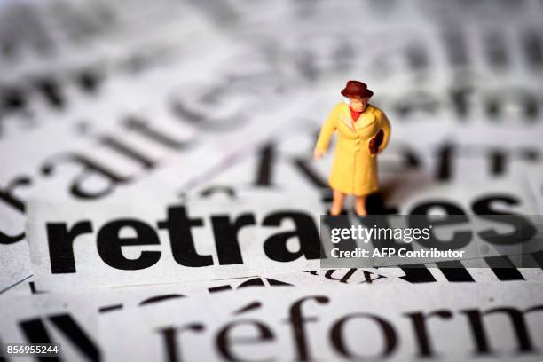 Photo prise le 19 juin 2013 à Paris, d'un personnage miniature photographié sur différentes coupures de journaux traitant du sujet de la réforme des...