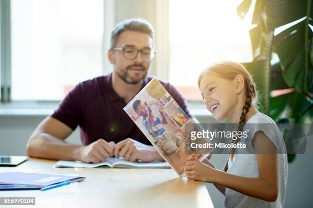 spending time with his daughter - reading magazine stock pictures, royalty-free photos & images