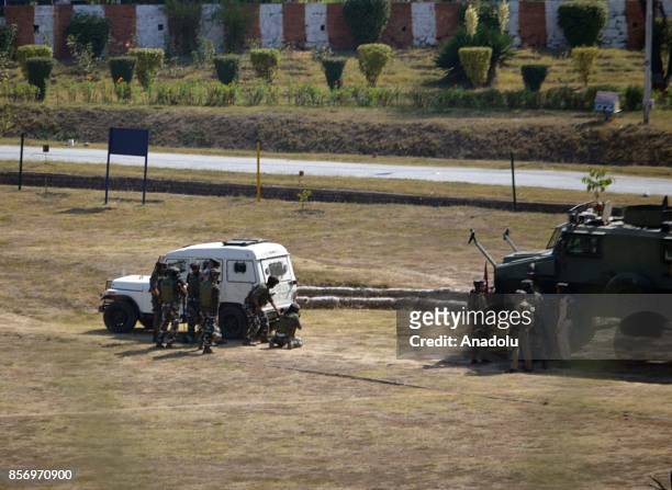 Indian army men take cover near the building where last suspected militant was believed to be holed up in Humhama on the outskirts of Srinagar the...