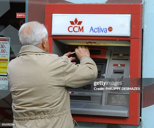 Man withdraws money from a Caja de Ahorros Castilla La Mancha savings bank branch in Madrid, on March 30, 2009. Spain's central bank took over a...