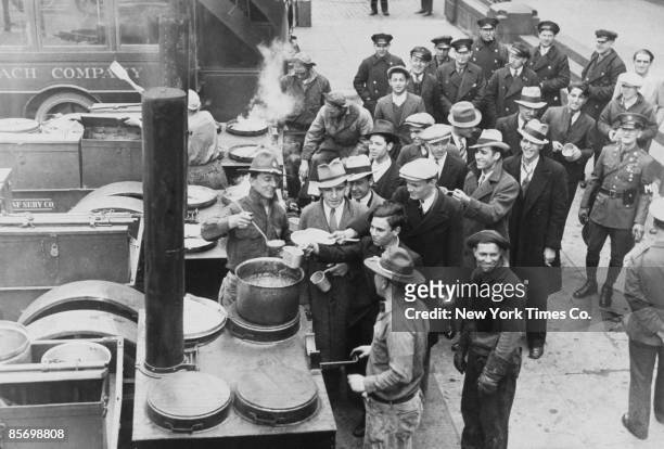 Recruits to a New Deal reforestation service receive a meal from a army soup kitchen at South Street, New York City, 4th August 1933.