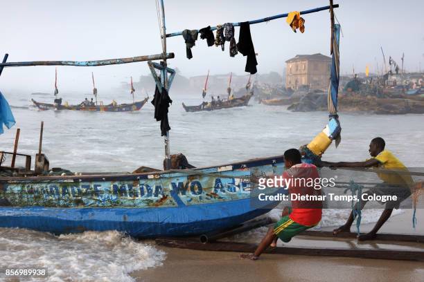 fishermen pull a boat in winneba, ghana - dietmar temps stock-fotos und bilder