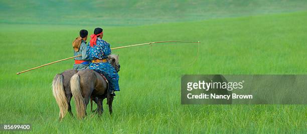 two mongolia horsemen in grassland riding off - xilinhot stock pictures, royalty-free photos & images