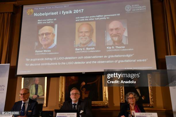 Photos of the winners of the Nobel Prize in Physics Rainer Weiss, Barry C. Barish and Kip S. Thorne are seen on a screen as Secretary General of the...