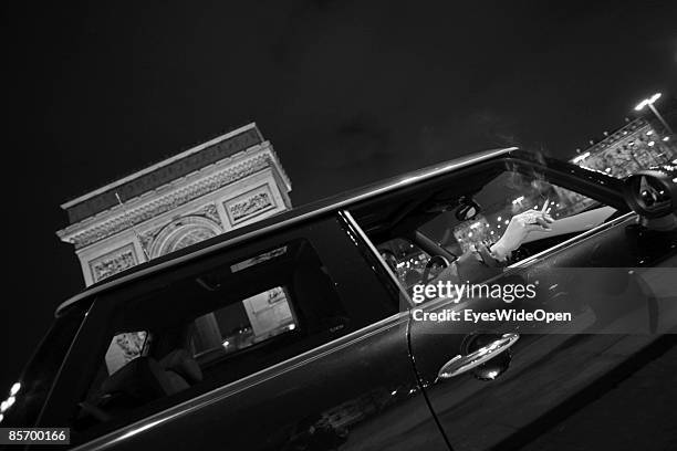 Woman smoking a cigarette in front of the famous france landmark Arc de Triomphe de L´Etoile in Paris, France on February 25,2009. It was built in...