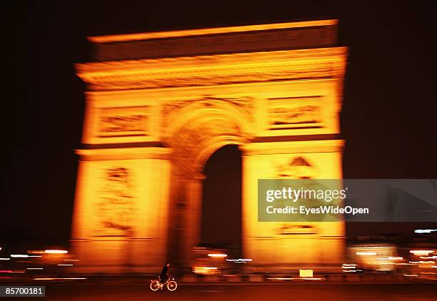 Cyclist in front of the famous france landmark Arc de Triomphe de L´Etoile in Paris, France on February 25,2009. It was built in 1806 at the behest...