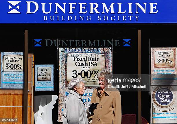 Two women stand outside a branch of the Dunfermline Building Society on March 30, 2009 in Dunfermline, Scotland. The Nationwide Building Society is...
