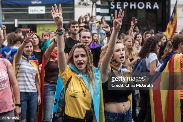 Peoiple chant slogans and sing songs as thousands of citizens gather in Plaza Universitat during a regional general strike to protest against the...