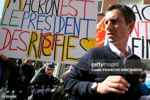 La France Insoumise leftist party's MP Francois Ruffin stands next to a sign reading "Macron president of the riche people" during a protest over the...