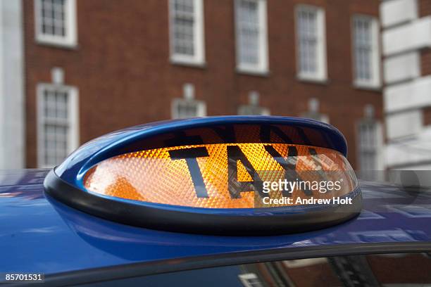 taxi cab, orange roof sign light on, london  - london taxi ストックフォトと画像