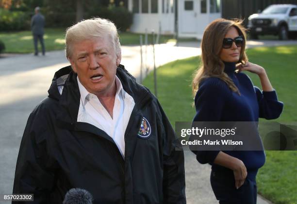 President Donald Trump speaks to the media while flanked by first lady Melania Trump before departing on Marine One from the White House, on October...