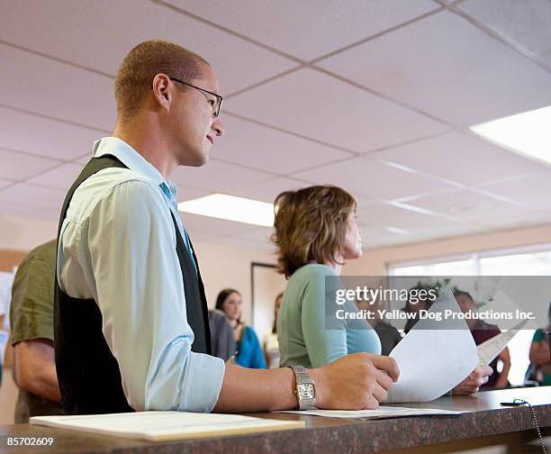 applicants  waiting at counter - dmv stock pictures, royalty-free photos & images