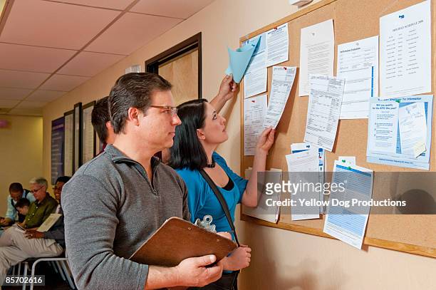 people searching bulletin board for job openings - tablón de anuncios fotografías e imágenes de stock