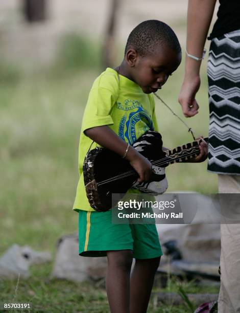 Madonna's adopted son David Banda plays with a guitar as he visits a project previously set up by Madonna's Raising Malawi Foundation at the Namitete...