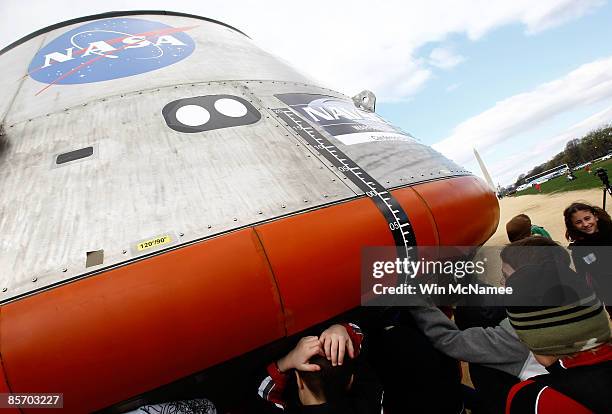 Schoolchildren gather around a full-size mockup of the Orion crew exploration vehicle which NASA displayed on the National Mall March 30, 2009 in...