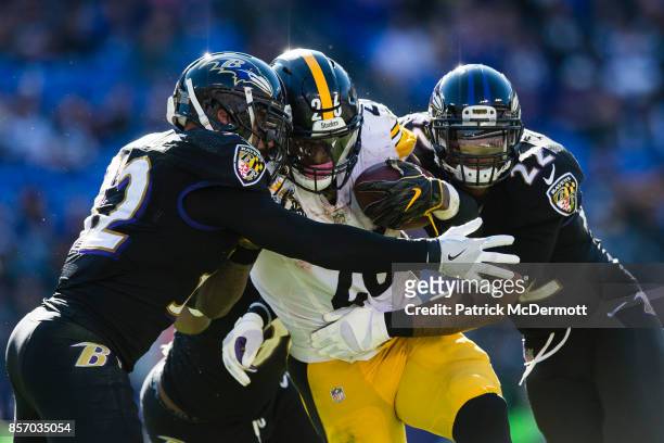Running back Le'Veon Bell of the Pittsburgh Steelers is tackled by free safety Eric Weddle and cornerback Jimmy Smith of the Baltimore Ravens in the...