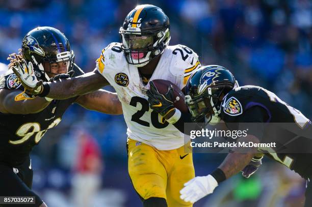 Running back Le'Veon Bell of the Pittsburgh Steelers is tackled by defensive end Za'Darius Smith and cornerback Jimmy Smith of the Baltimore Ravens...