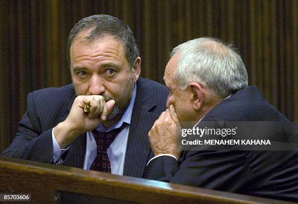 Israeli far-right Yisrael Beitenu party leader Avigdor Lieberman talks to his party member Yitzhak Aharonovitch during a Knesset session...