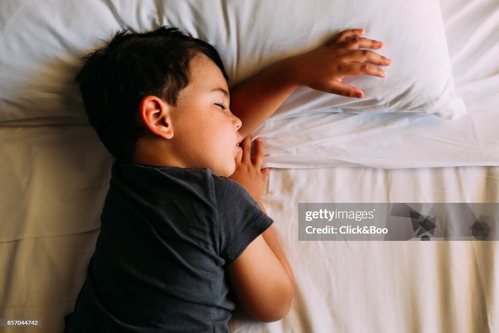 Boy sleeping in his bed