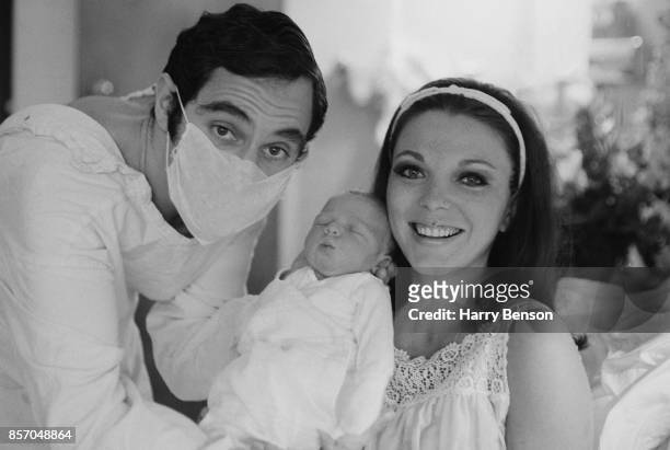 English actress and author Joan Collins and English actor and singer Anthony Newley hold their newly born baby Sacha Newley, 24th September 1965.