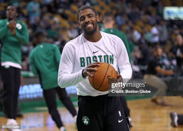 Boston Celtics' Kyrie Irving flashes a smile during pre-game warmups before the opening tap-off to his first game in a Boston uniform. The Boston...