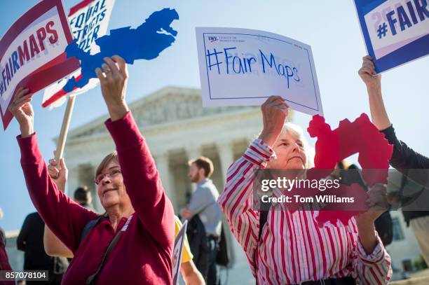 Shirley Connuck, right, of Falls Church, Va., holds up a sign representing a district in Texas, as the Supreme Court hears a case on possible...