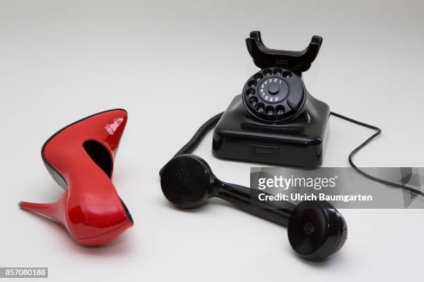 Symbol photo on the topics phone sex, prostitution, loneliness, etc. The photo shows a red women's shoe and a dial phone.