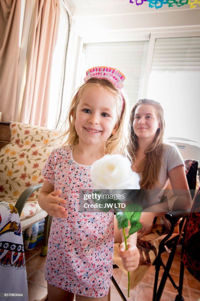 Girl 4-5 years holding white rose