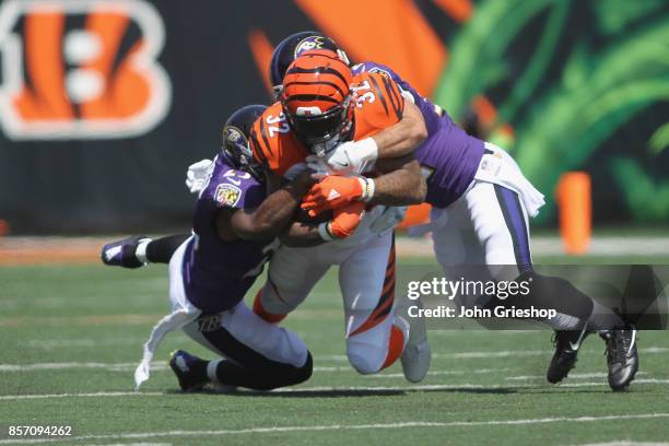 Jeremy Hill of the Cincinnati Bengals runs the football upfield against Eric Weddle of the Baltimore Ravens during their game at Paul Brown Stadium...